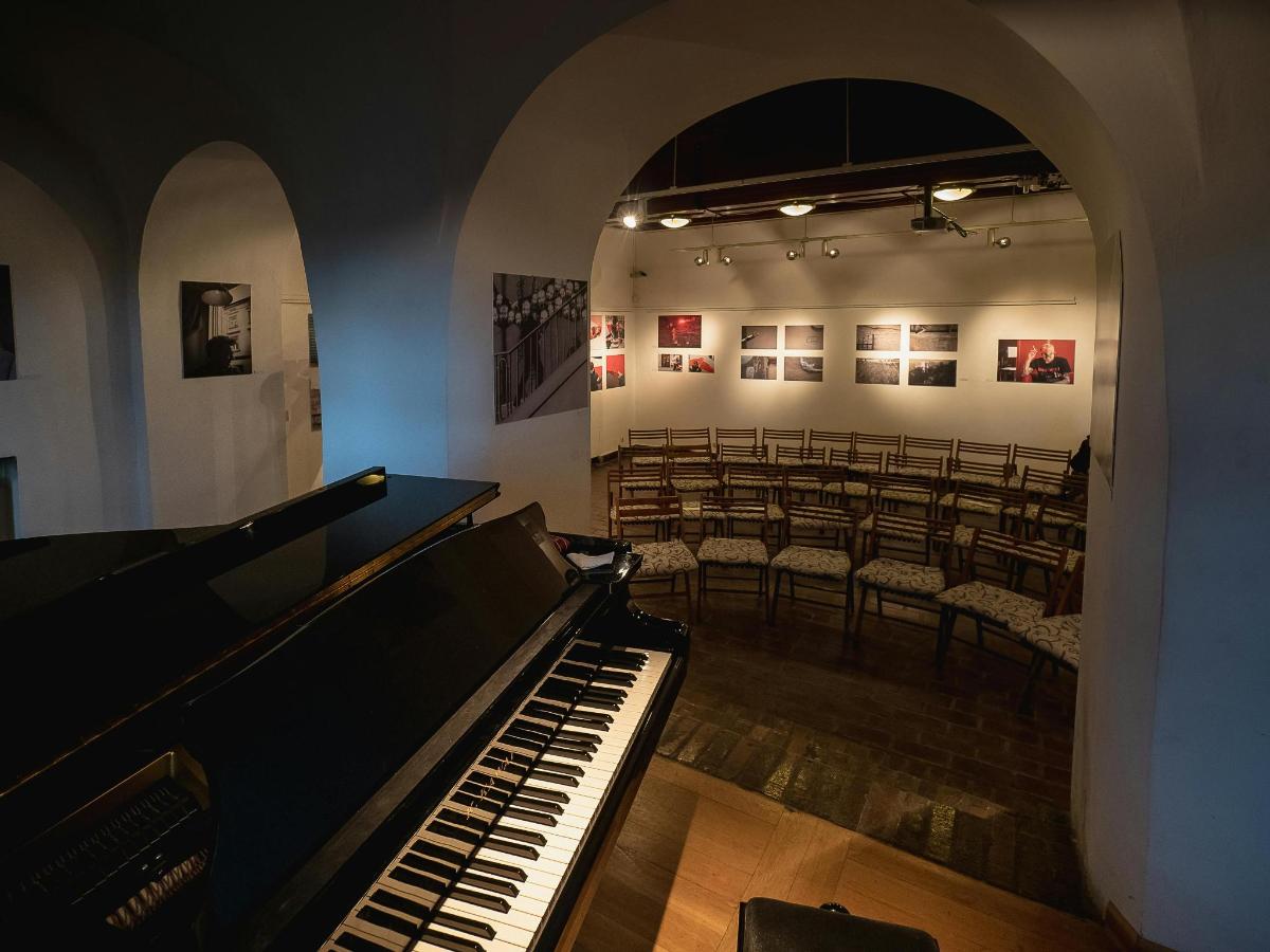 a room with a piano and a group of chairs