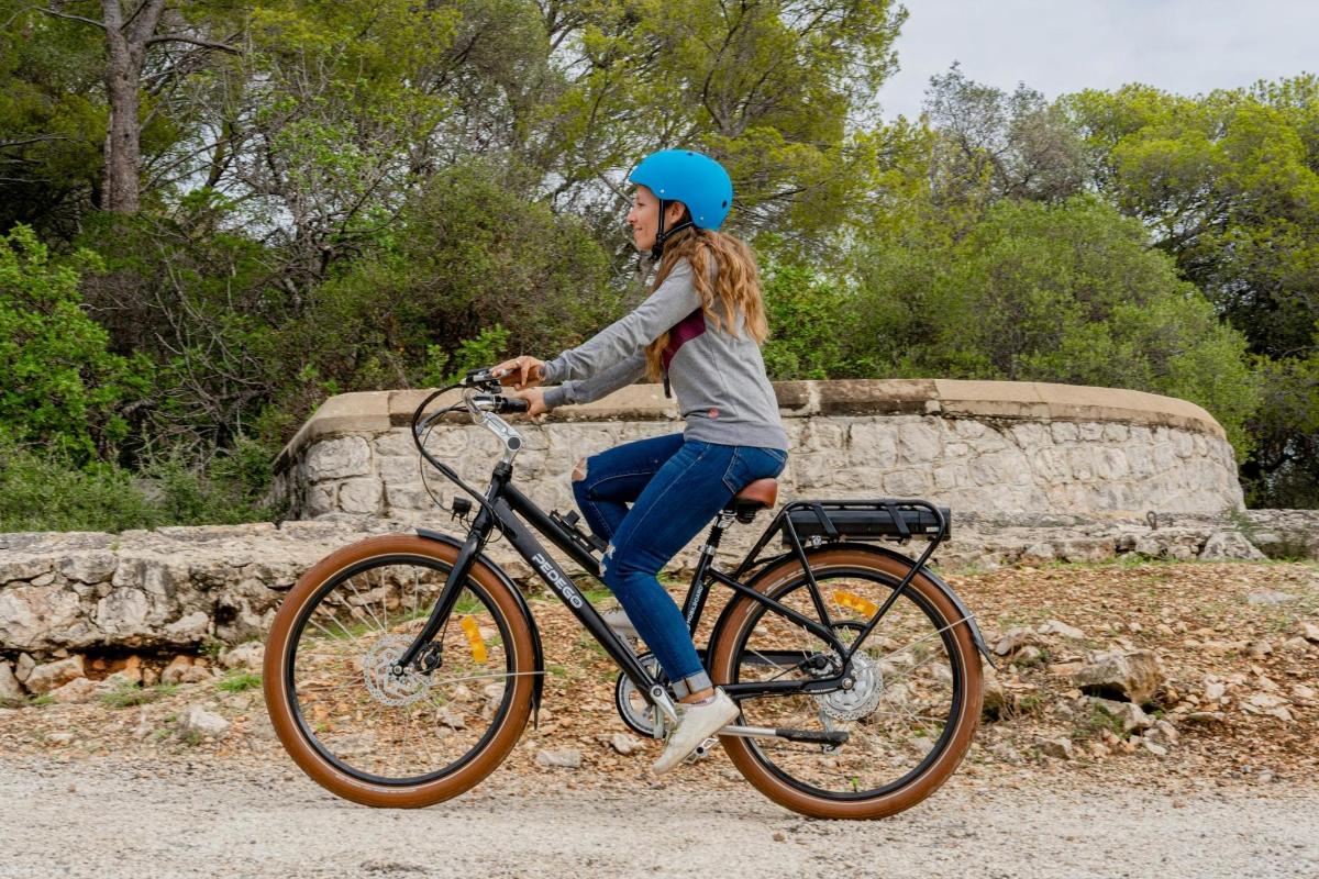 青いヘルメットをかぶって自転車に乗っている女性