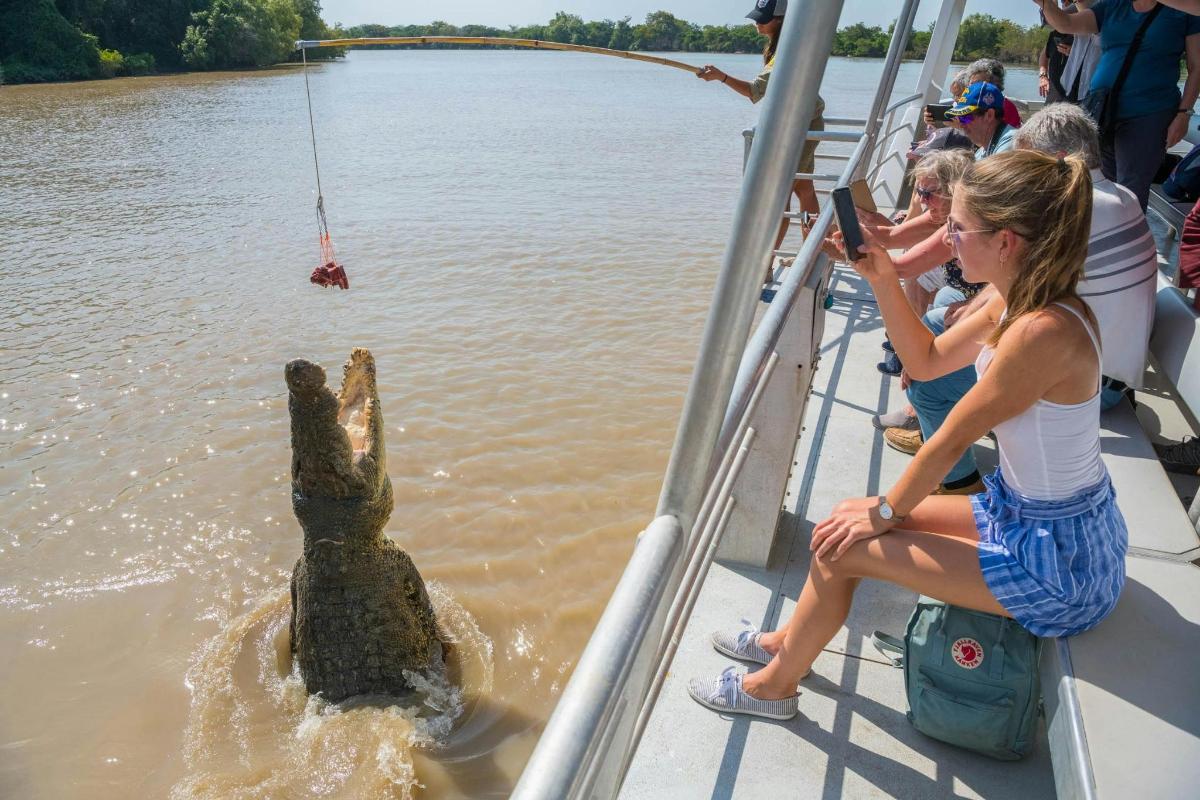 a hippo is in the water while a woman is taking a picture of it