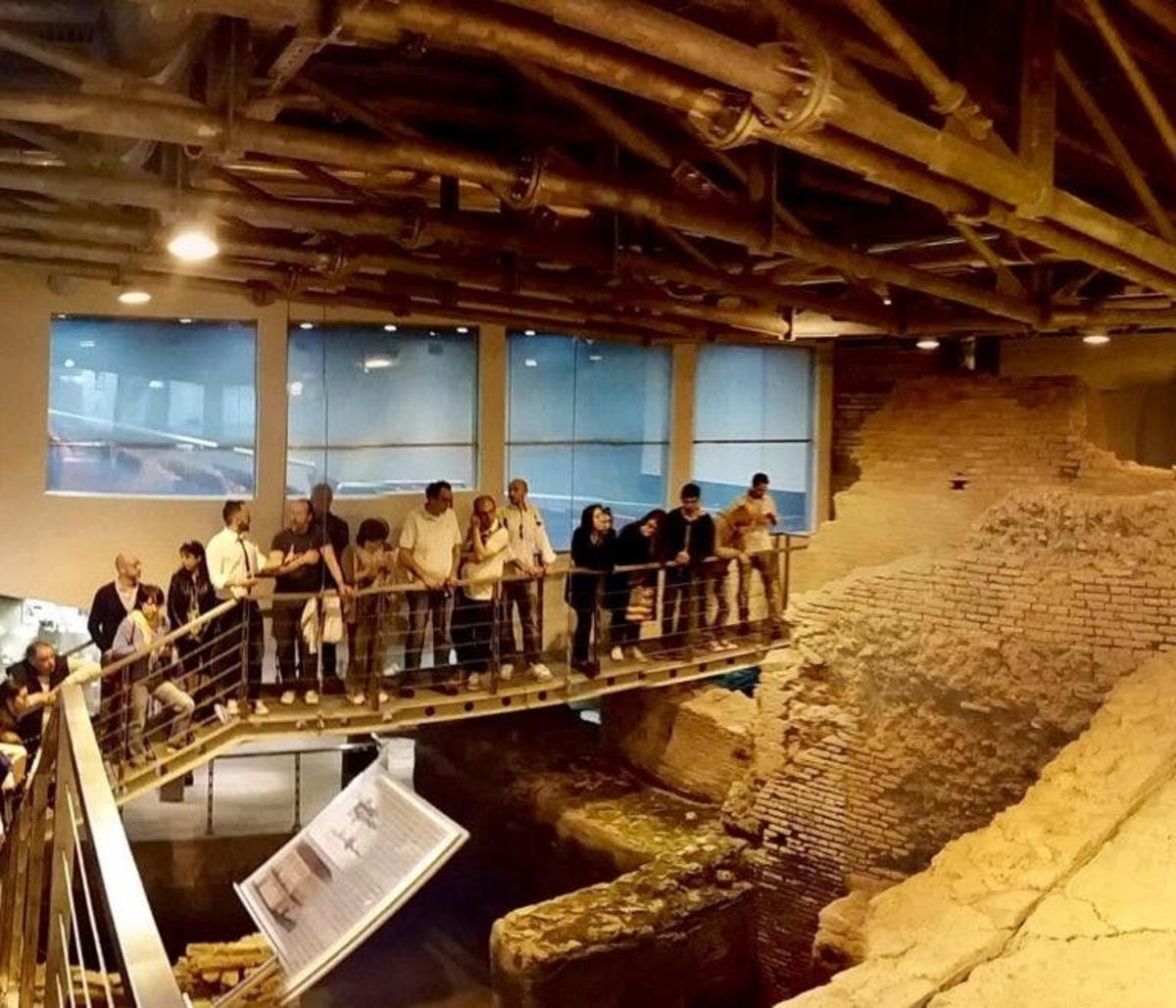 a group of people standing on a bridge in a museum