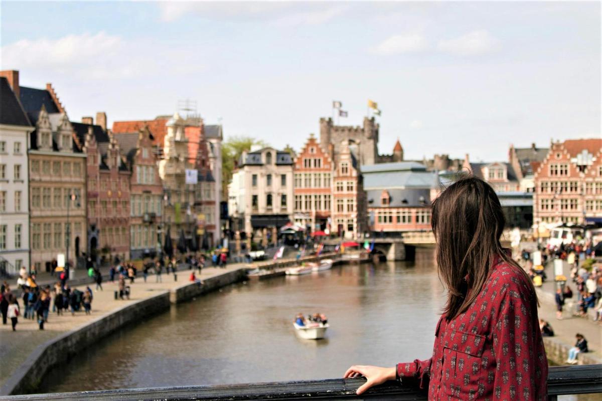 a woman standing on a bridge over a river