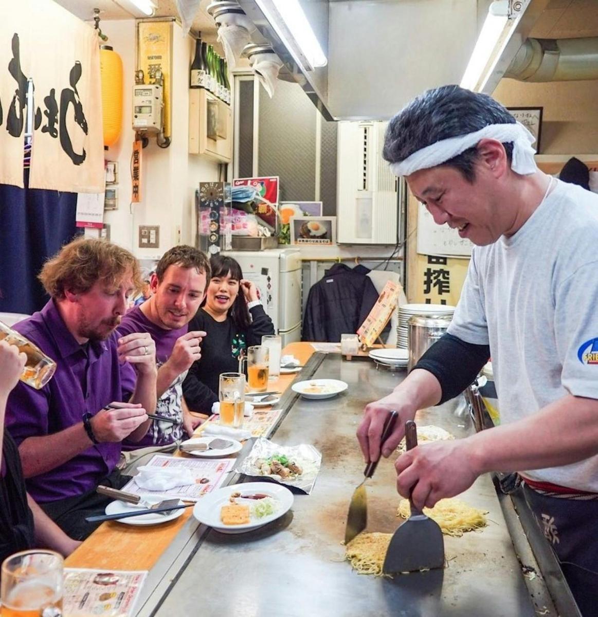a group of people sitting around a table eating food