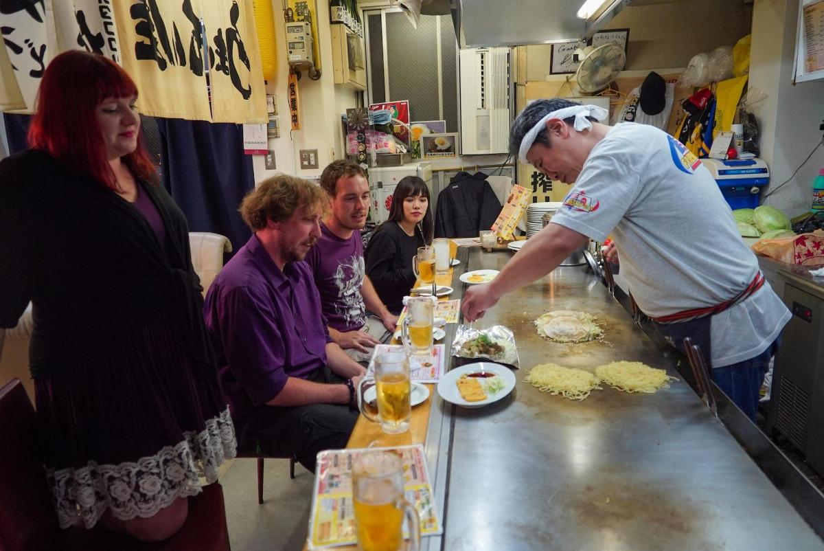 a group of people sitting around a table preparing food