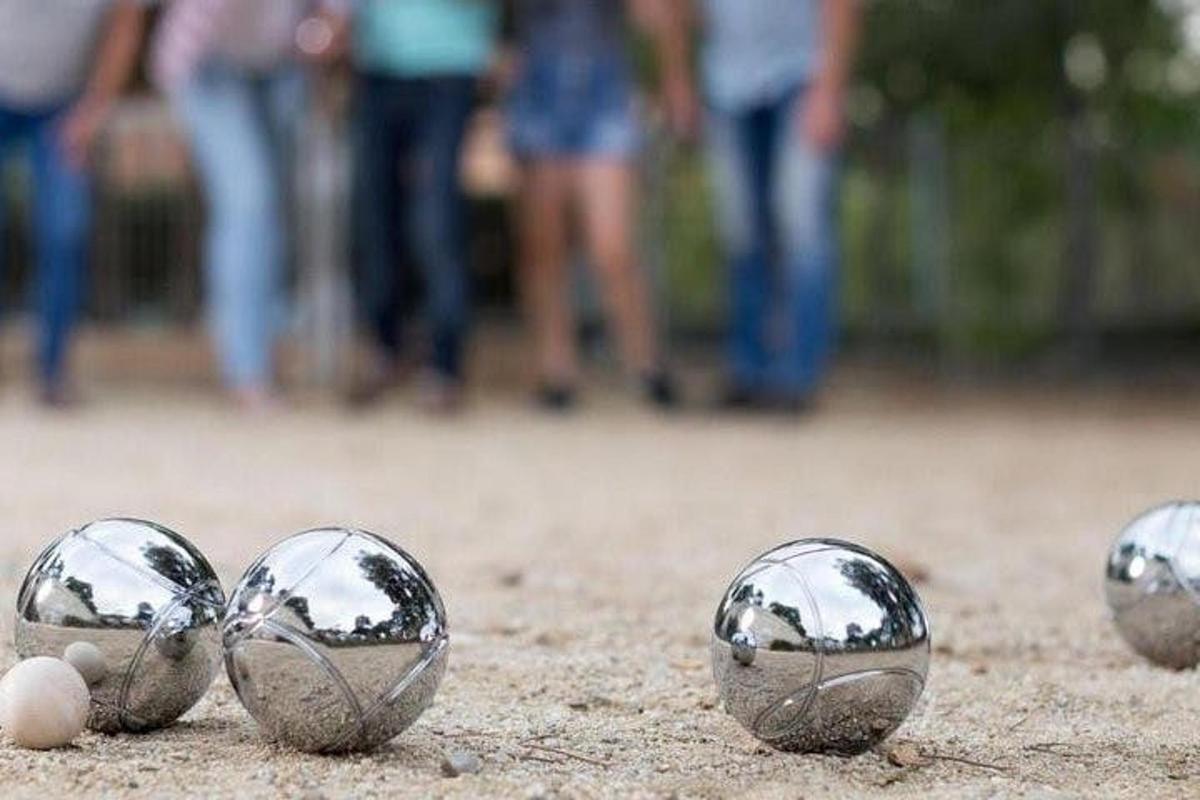 quattro sfere di metallo a terra con persone sullo sfondo