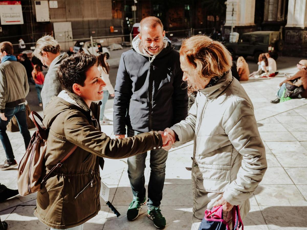 a man and woman shaking hands on the street