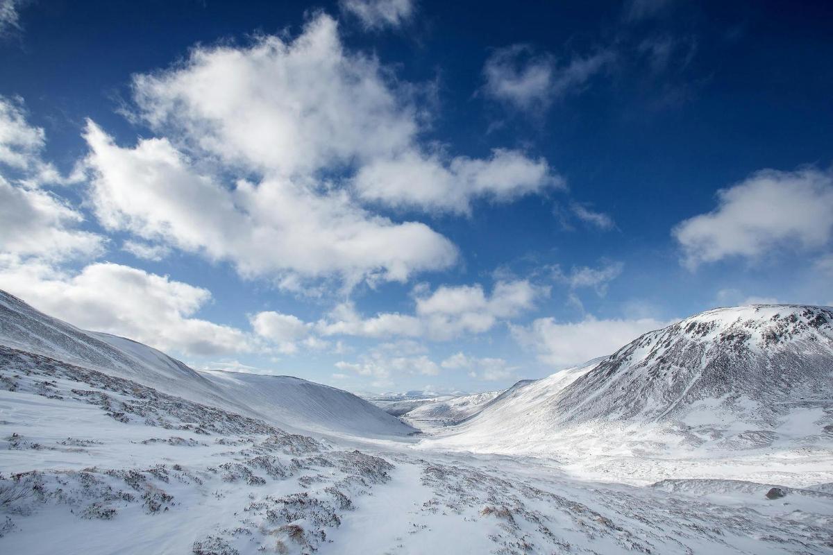 a snow covered mountain with a blue sky and clouds
