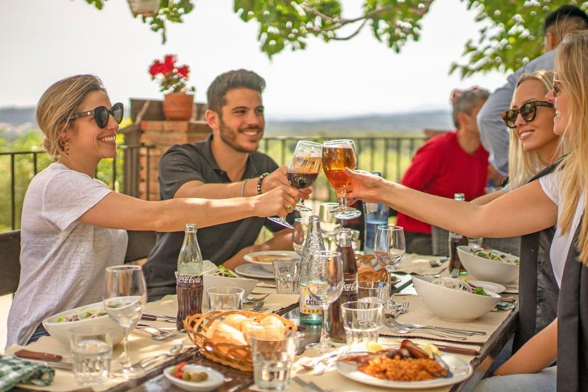 um grupo de pessoas sentadas ao redor de uma mesa bebendo vinho