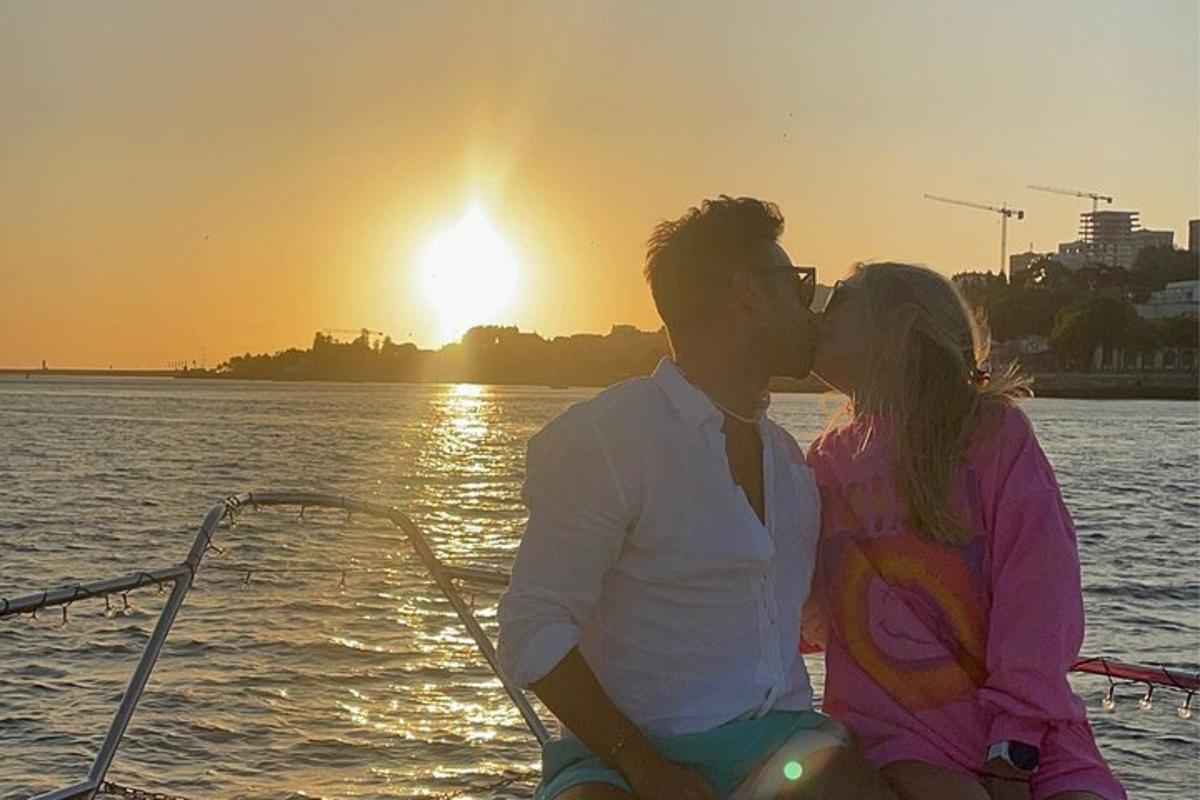 un uomo e una donna seduti su una barca che si baciano