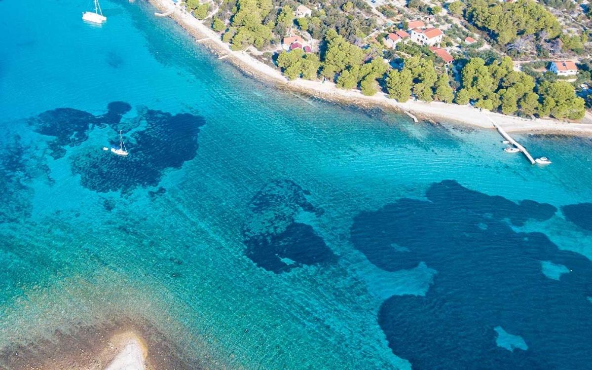 an aerial view of a beach with blue water
