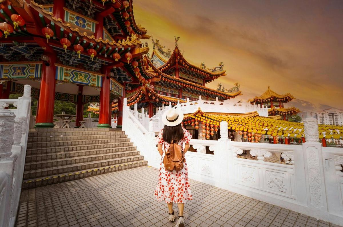 a woman in a dress standing in front of a building