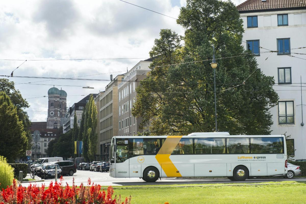 un autobús groc i blanc circulant per un carrer de la ciutat