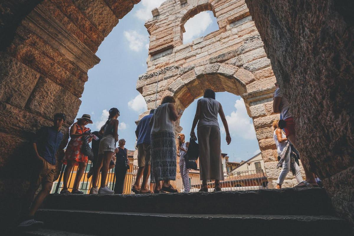 un gruppo di persone in piedi sotto un arco di pietra