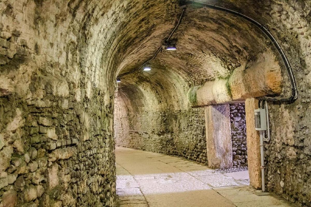 un vecchio tunnel di pietra con un muro di pietra