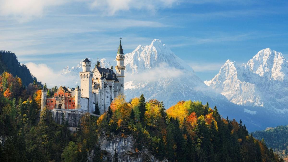 a castle on a hill with a mountain in the background