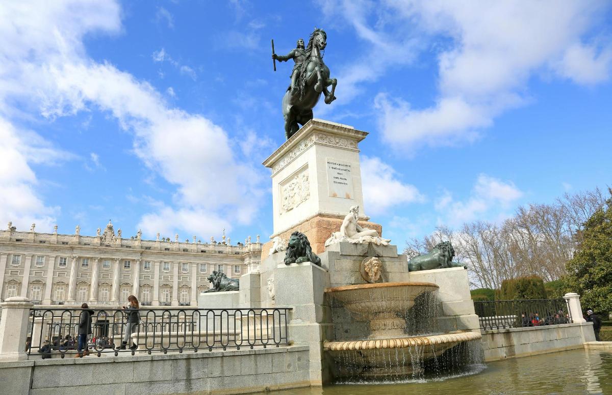 una statua davanti a una fontana di fronte a un edificio
