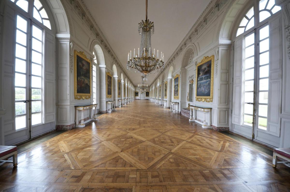 a hallway in a palace with a chandelier