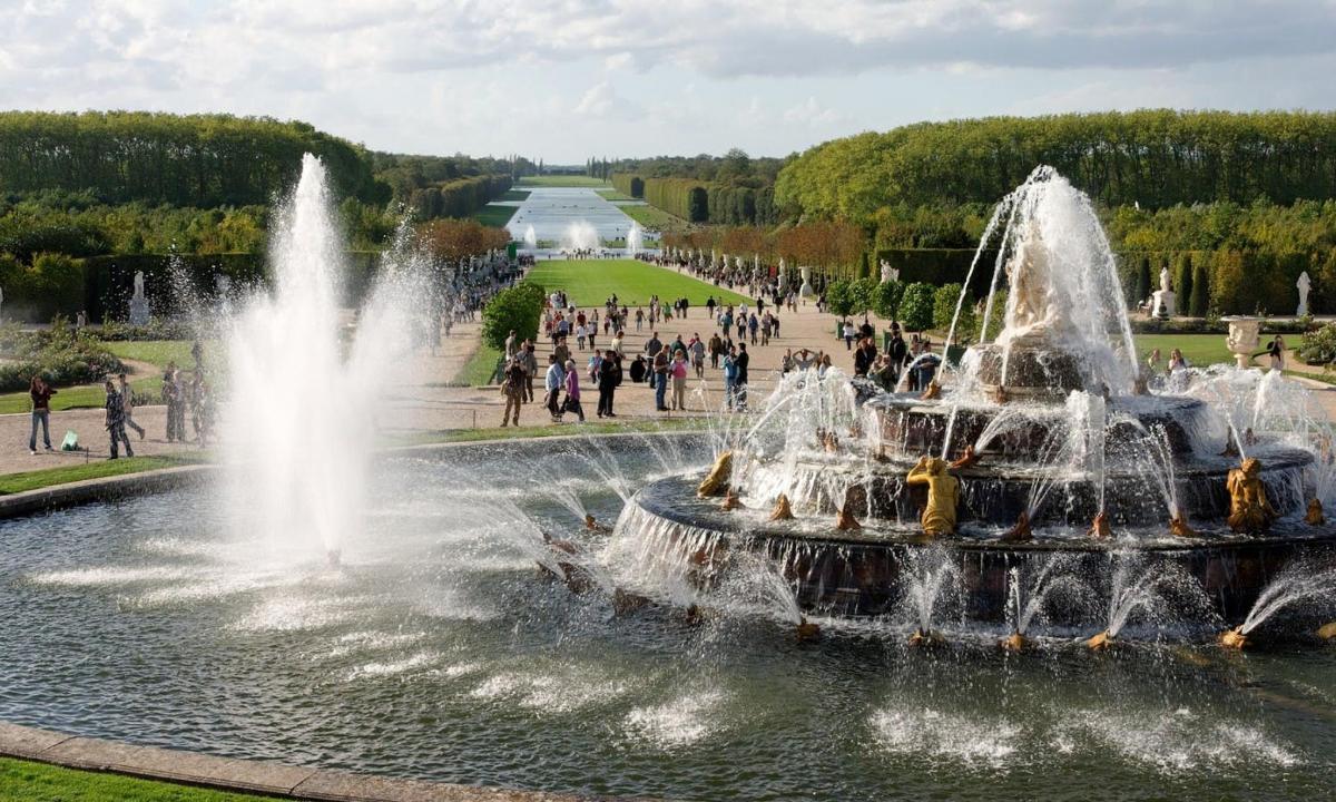 a fountain in a park with people standing around it