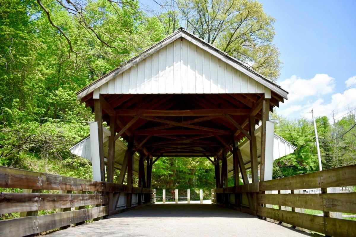 a wooden covered bridge with a wooden fence