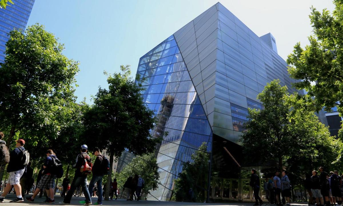 people walking in front of a glass building