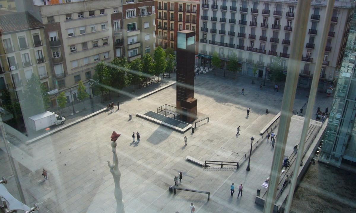 a group of people walking around a plaza in a city
