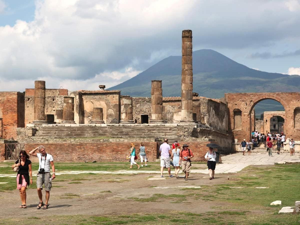 a group of people walking around the ruins of aniseum