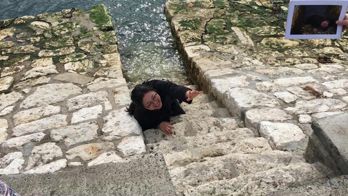 osoba lezecí po kamenných schodech vedle vody