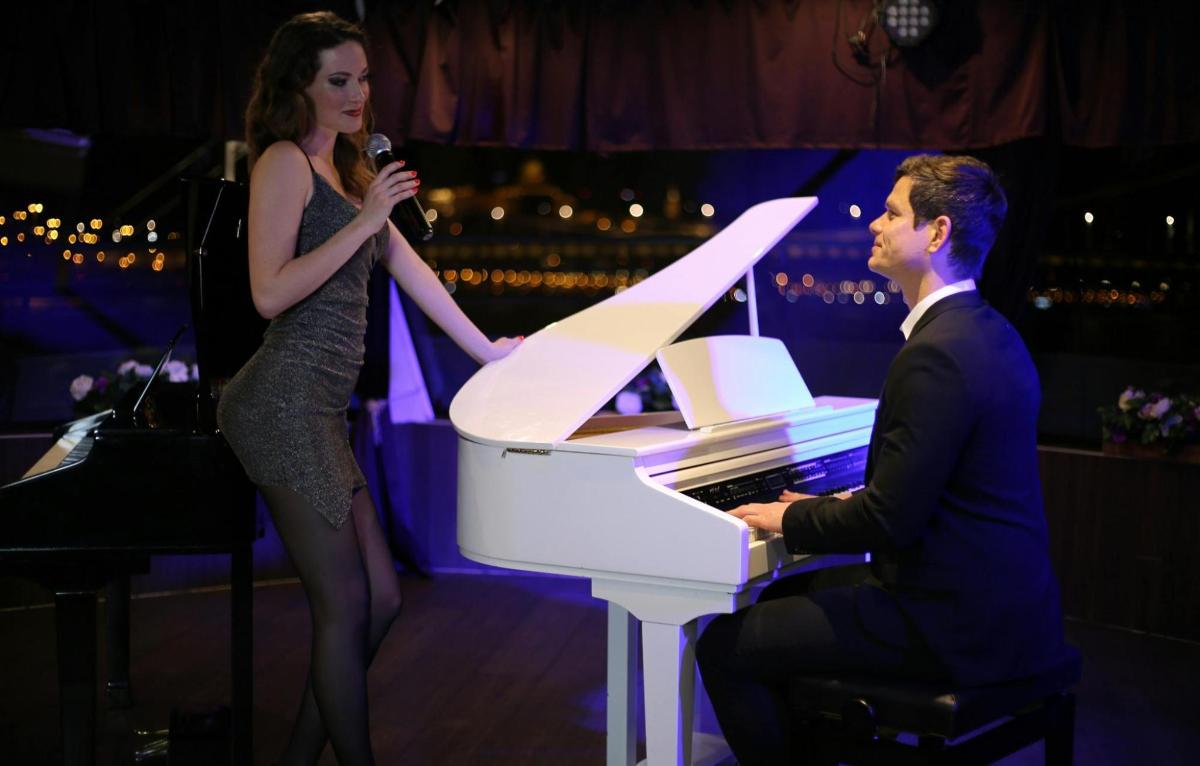 un hombre sentado al piano junto a una mujer
