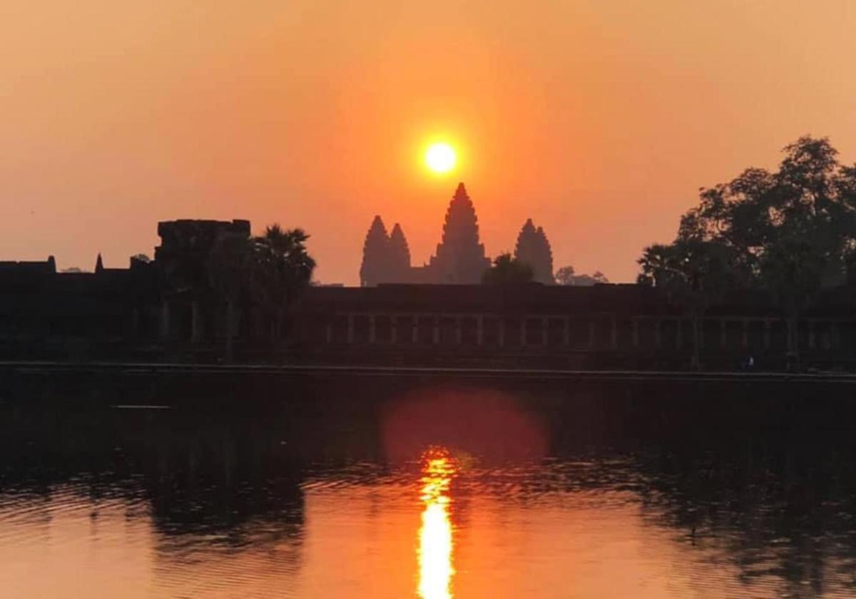 en solnedgang over vannet foran et tempel