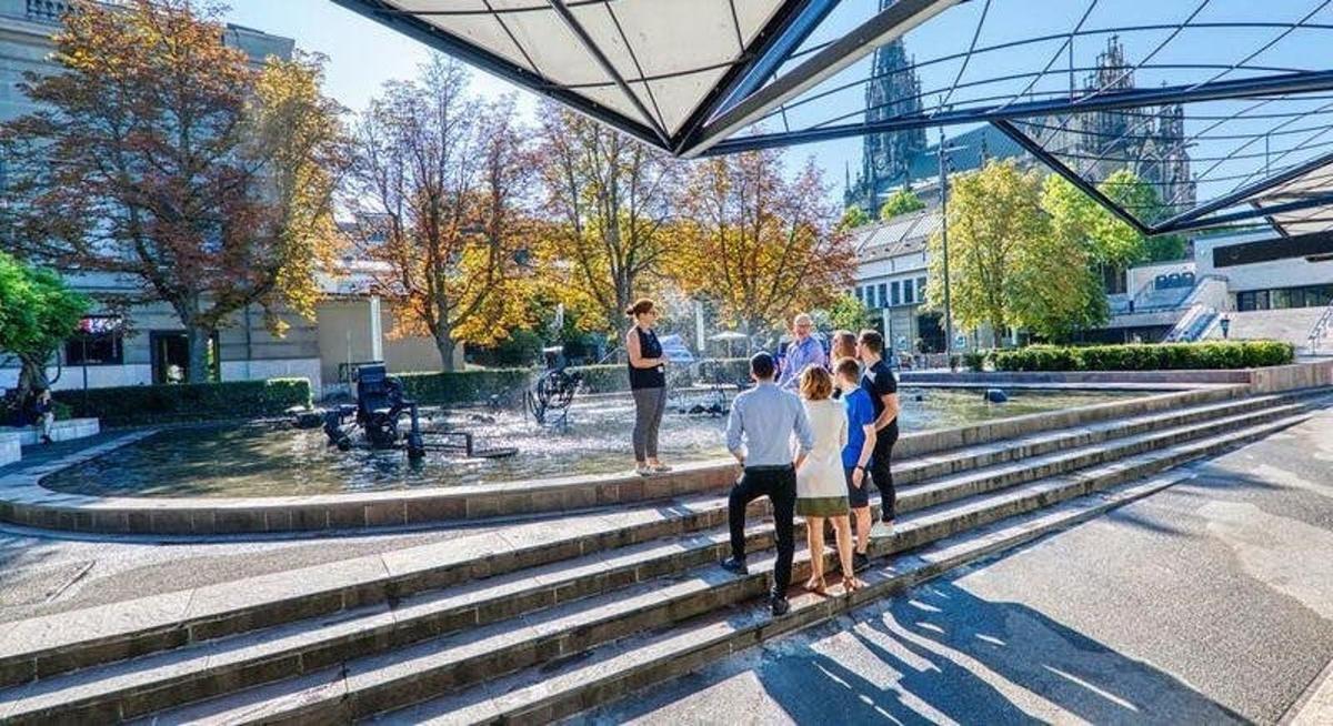 a group of people standing on the steps of a fountain