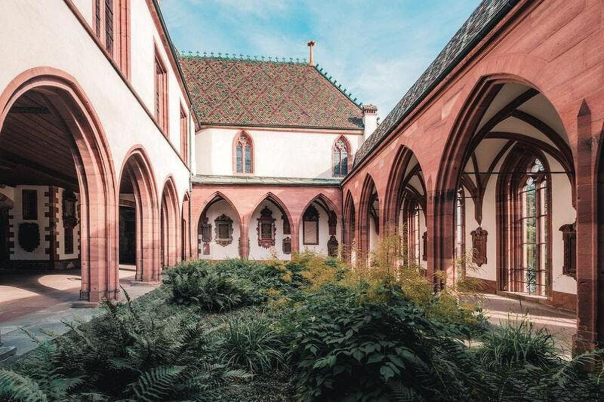 a building with arches and plants in a courtyard