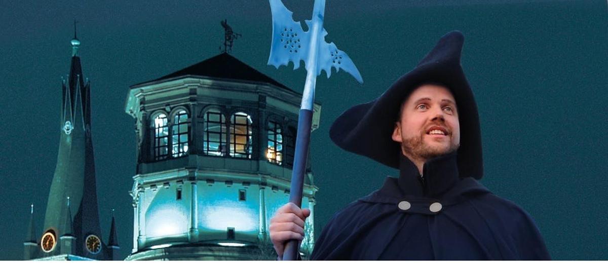 a man dressed as a wizard holding a flag in front of a tower