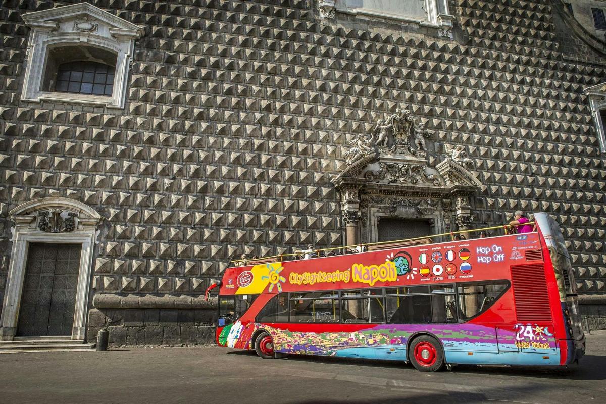 červený dvoupatrový autobus zaparkovaný před budovou