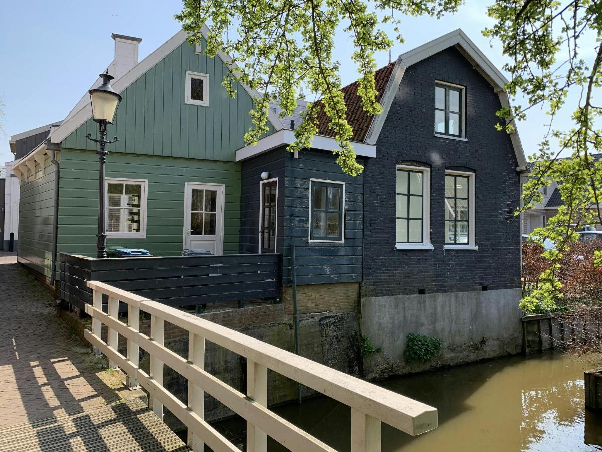 a green house with a river in front of it