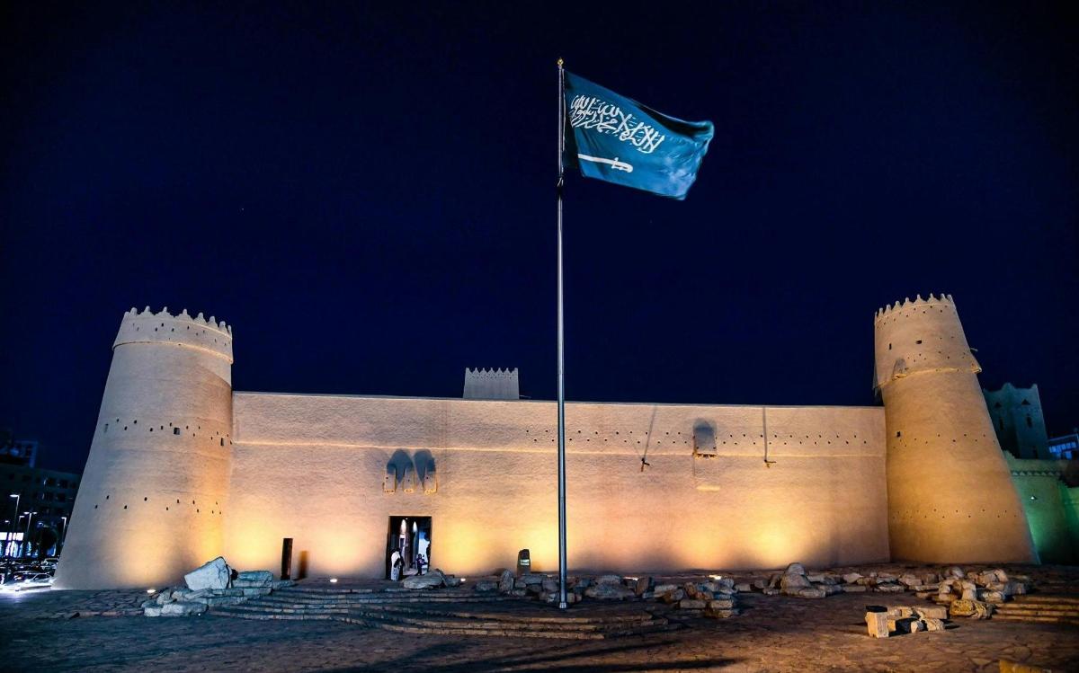 eine Burg mit einer Flagge davor in der Nacht