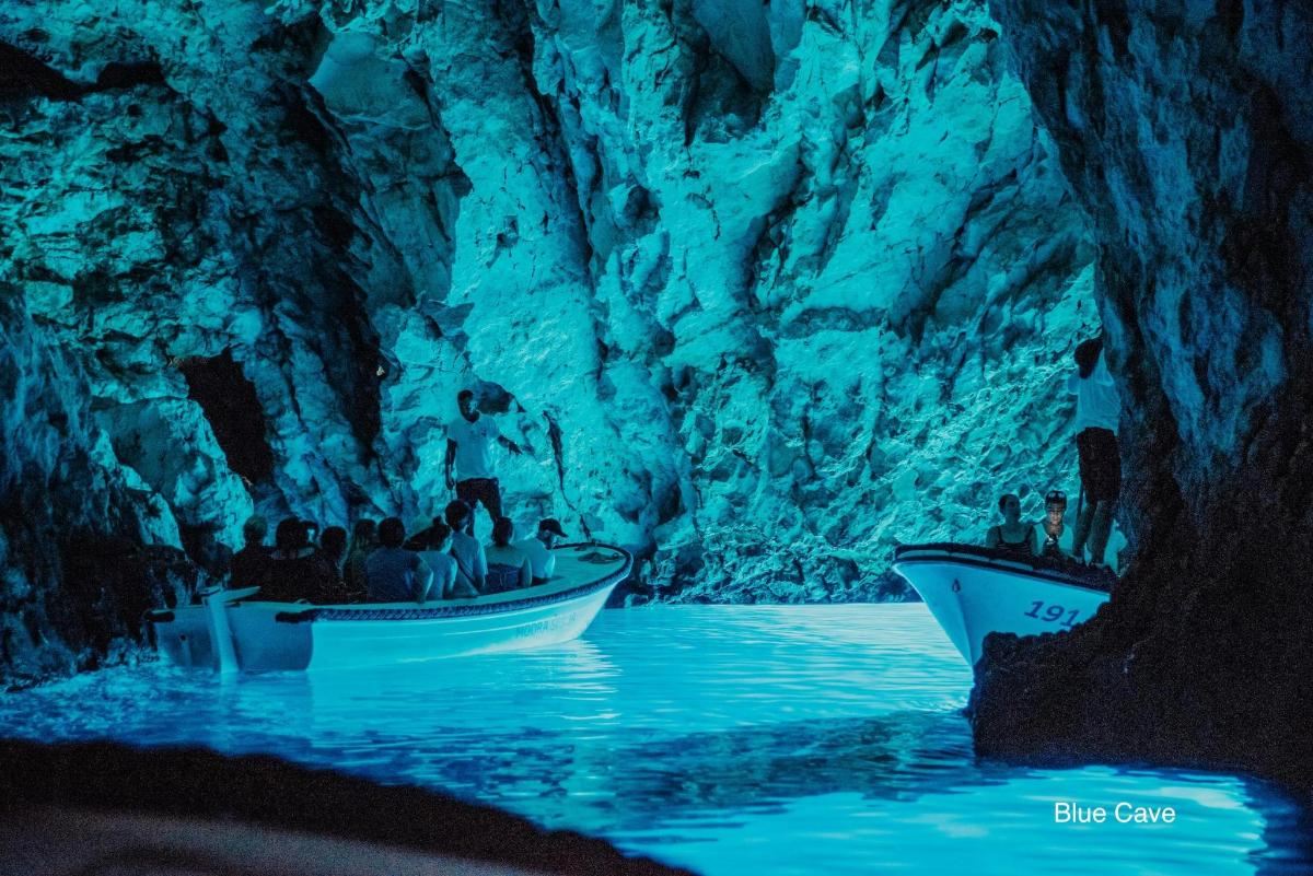 Un grupo de personas en botes en una cueva azul.
