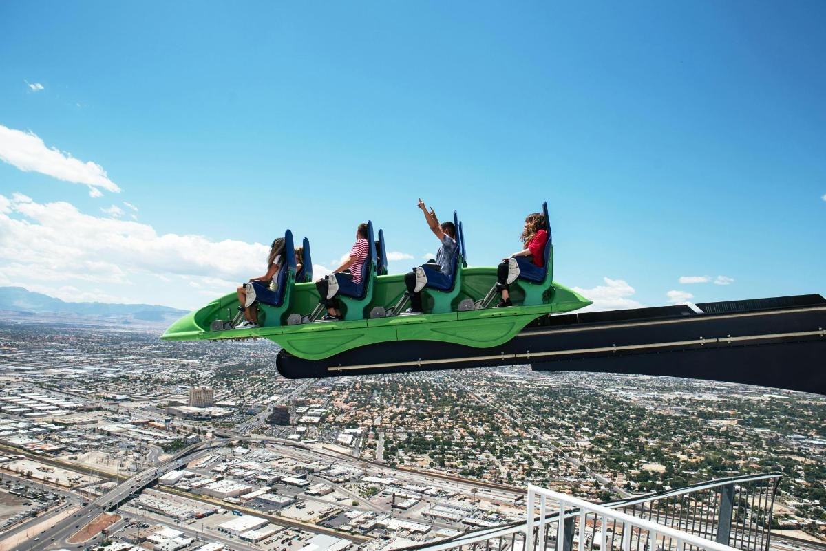 a group of people riding on a green airplane in the sky