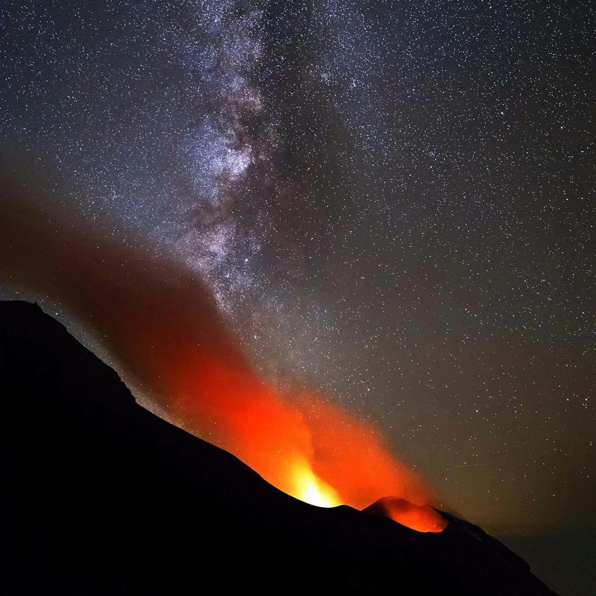 a volcano with the milky way in the sky