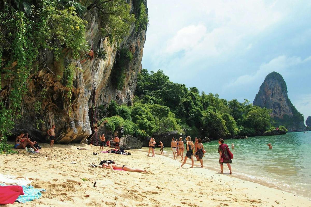 a group of people on a beach near the water