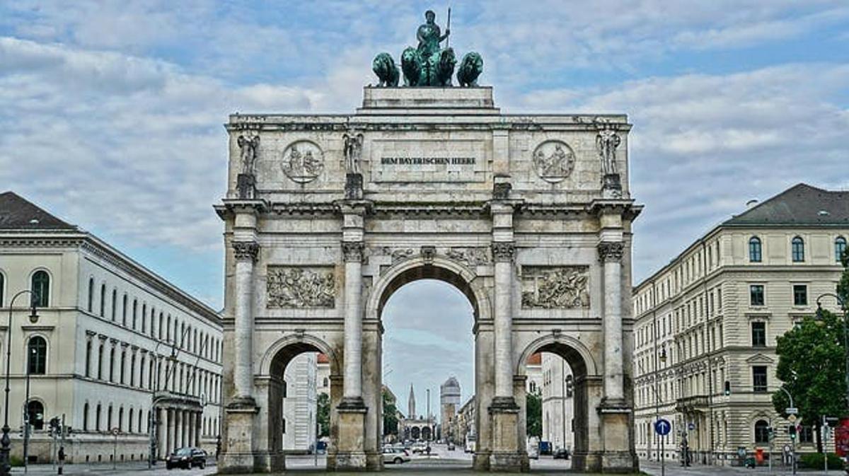Un gran monumento con una estatua delante de un edificio.