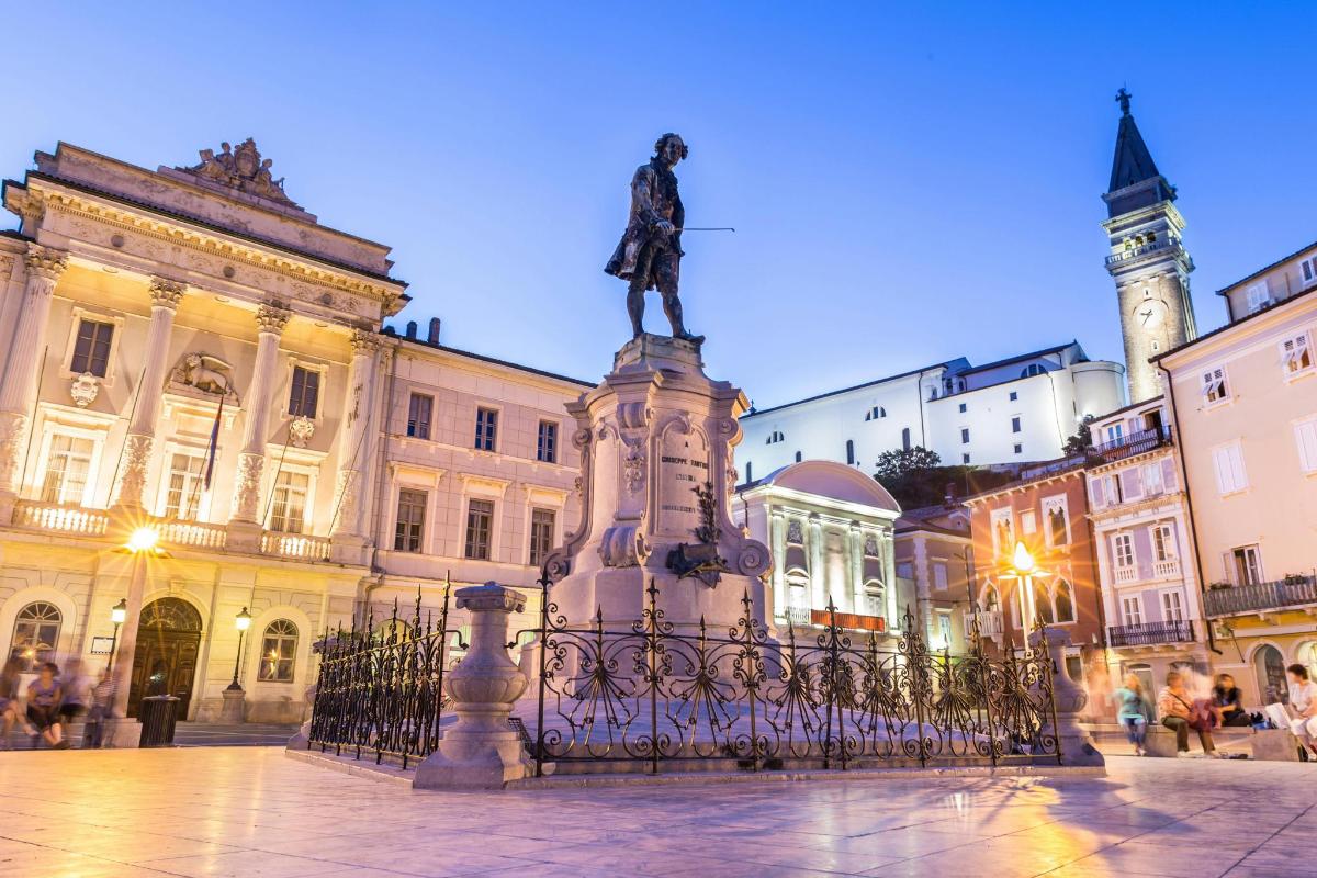 socha uprostřed města s budovami
