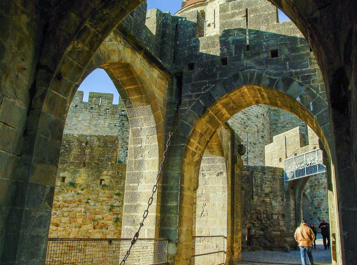 a man walking through an archway of a castle