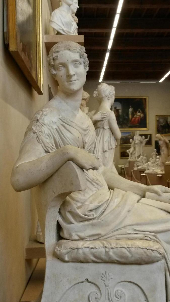 una statua di una donna seduta su un letto