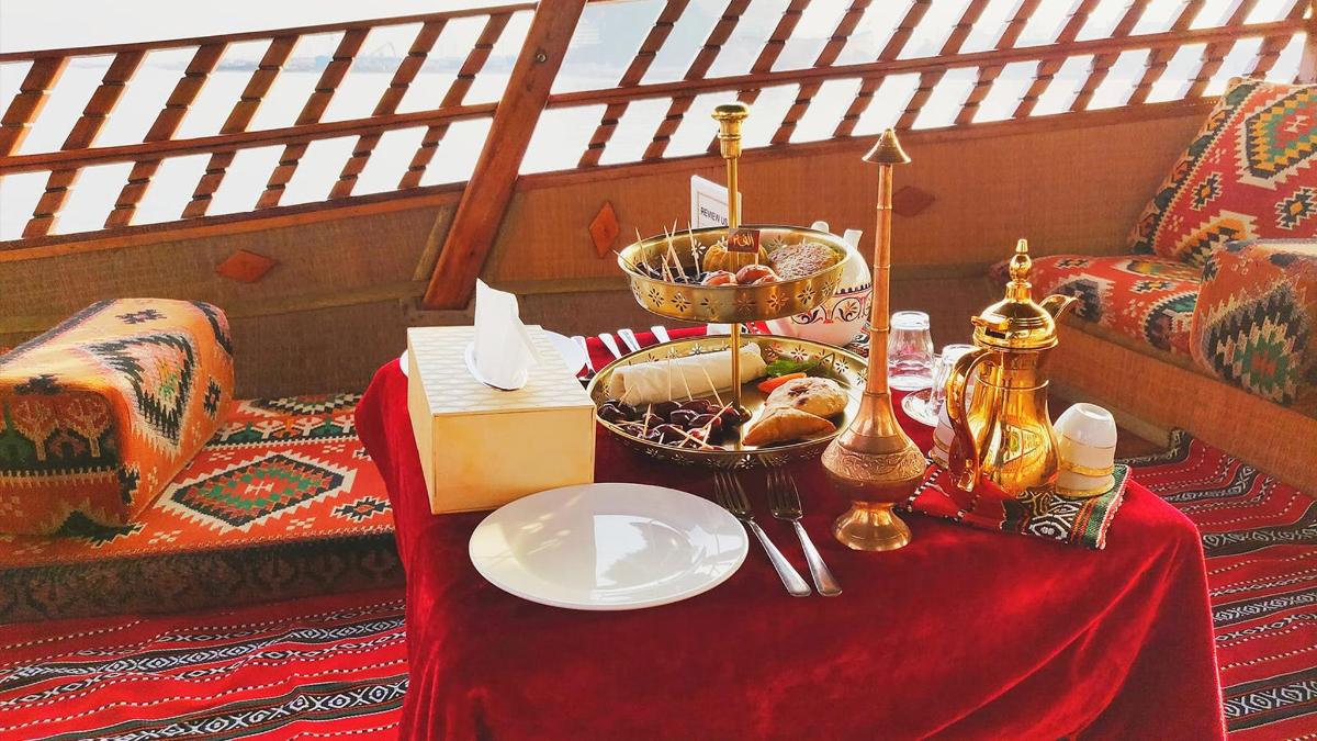 a table with a plate of food on a red table cloth