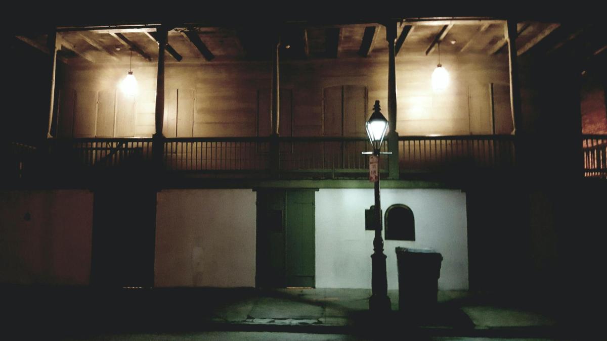 um poste de luz em frente a um prédio à noite