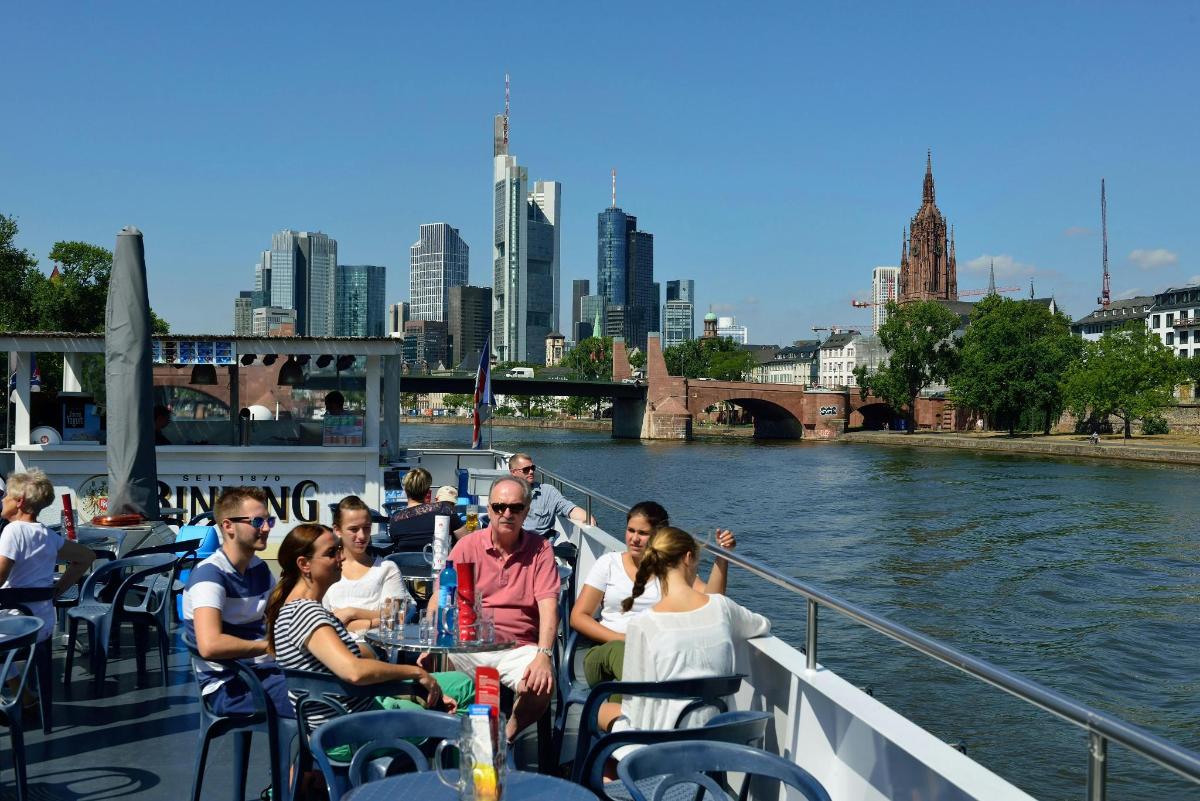 a group of people sitting on a boat on the river