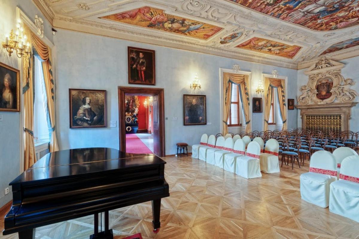 una habitació amb un piano en una habitació amb cadires