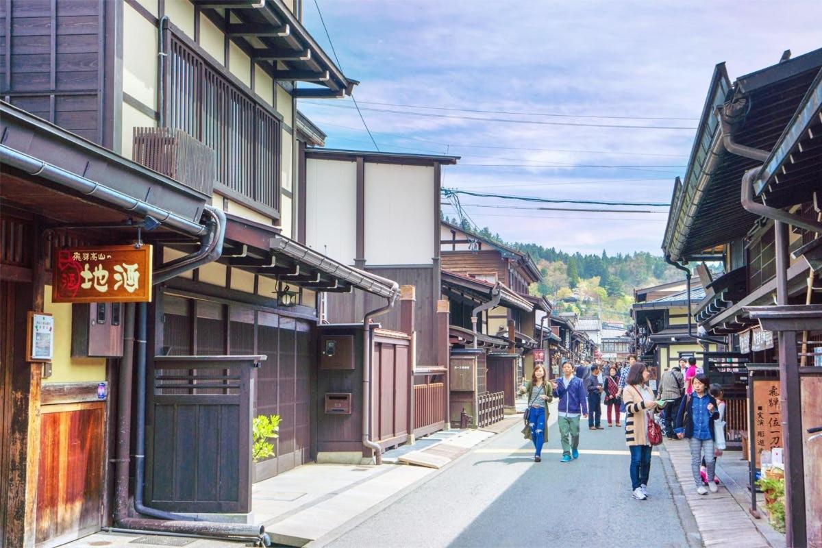 a group of people walking down a street in a town