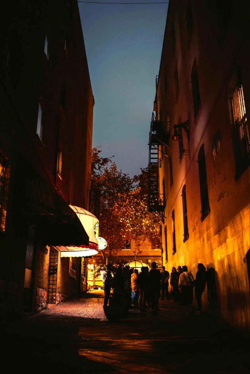 a group of people walking down a street at night
