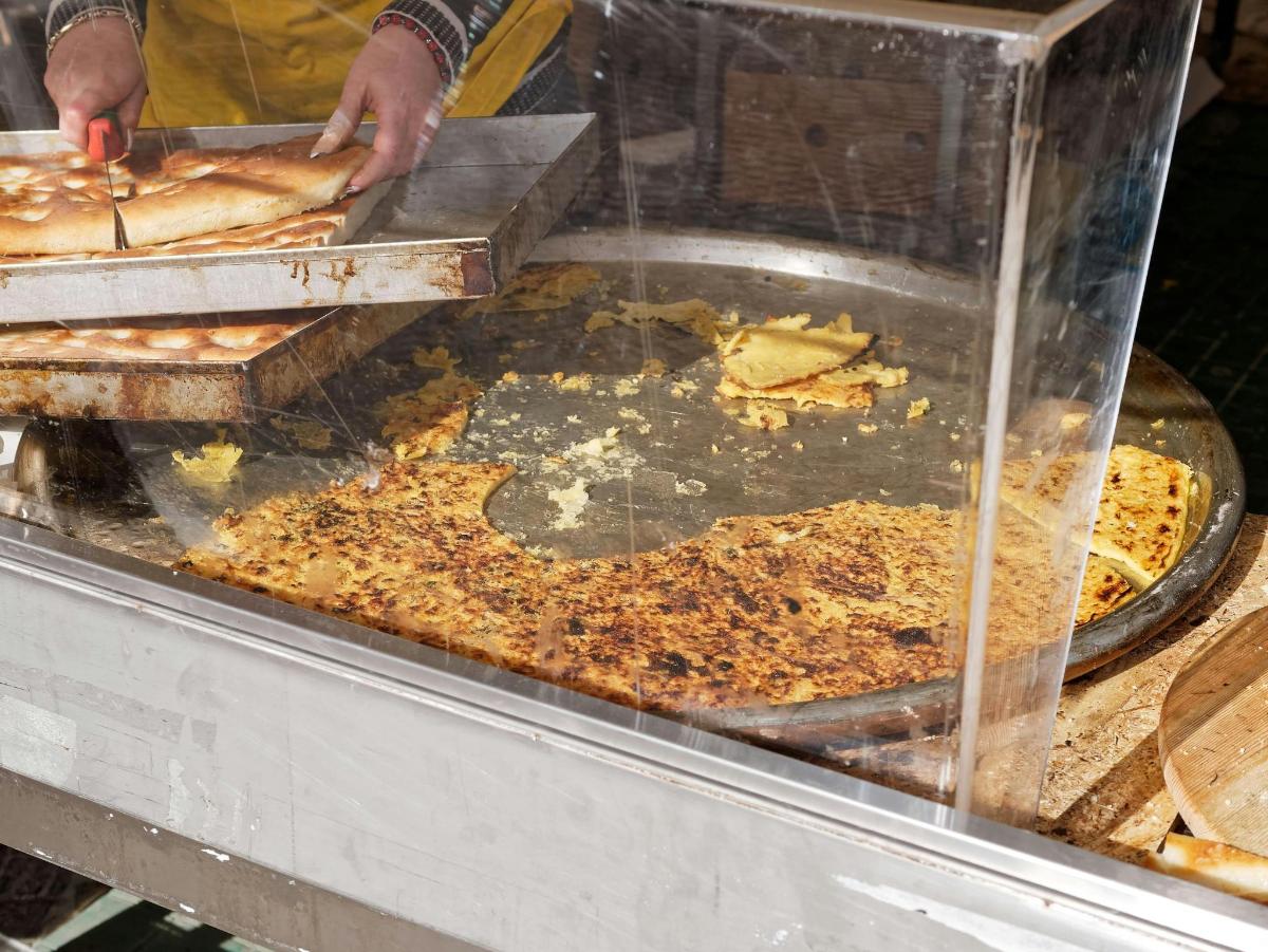 eine Person macht Pizza in einem Buffet