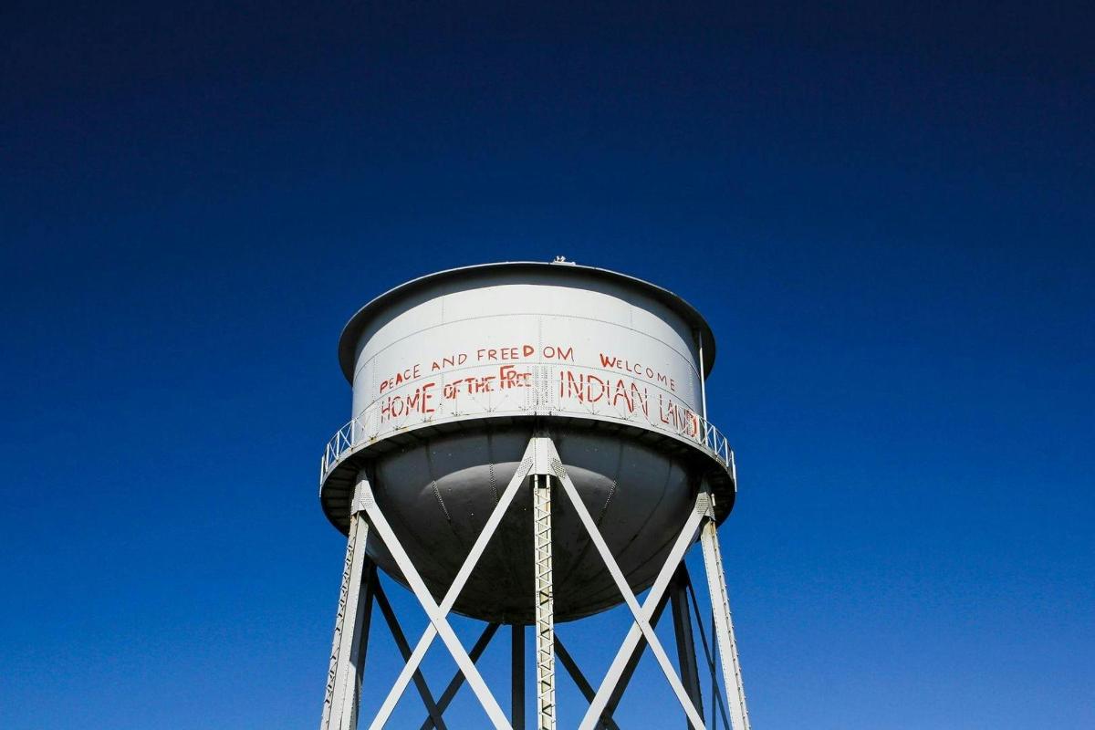uma torre de água com uma placa no topo